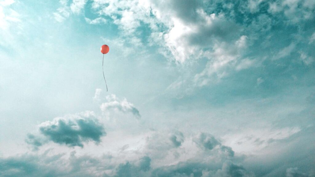Rød ballon flyder mod den blå himmel - Ren luft
